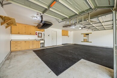 Oversized 3 car garage features built in cabinets