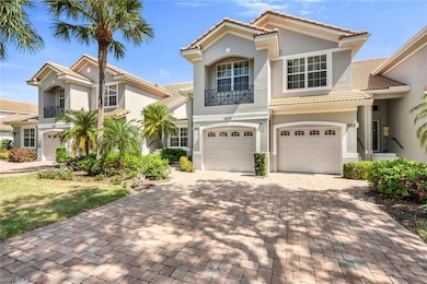 View of front of house with a garage, brick paver driveway, tile roof, and stucco exterior