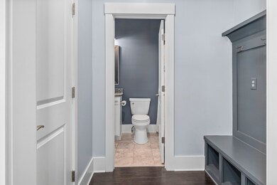 The mudroom, coat closet & view of the downstairs full bathroom.