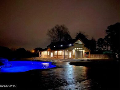 Pool at night featuring a patio, an outdoor pool, 