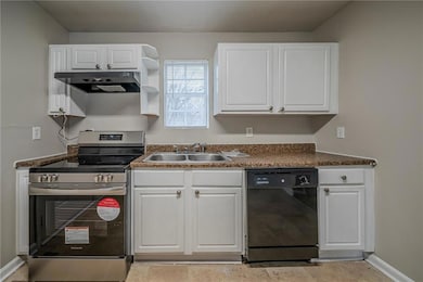 Kitchen featuring sink, dishwasher, white cabinetr