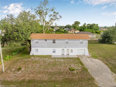 Back of house with asphalt driveway, an attached garage, and a lawn