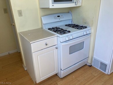 Kitchen featuring white appliances, light hardwood / wood-style floors, and white cabinetry