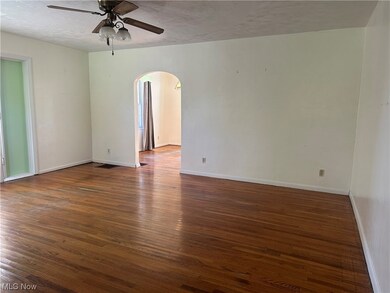 Empty room featuring a textured ceiling, dark hardwood floors, and ceiling fan