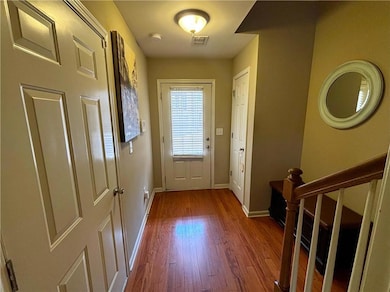 Doorway to outside with wood finished floors and baseboards
