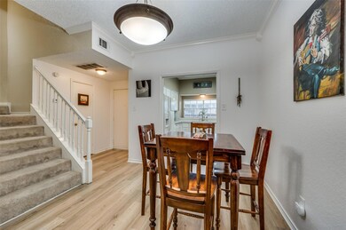 Dining room with sink, crown molding, light hardwo