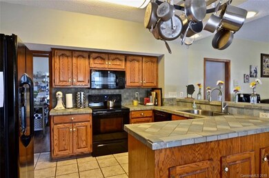Kitchen with tile countertops, tile flooring, whole house intercom recently updated.
