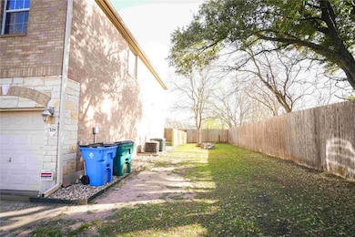 Fenced backyard with cooling unit and a garage