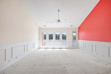 Carpeted spare room with visible vents, lofted cei