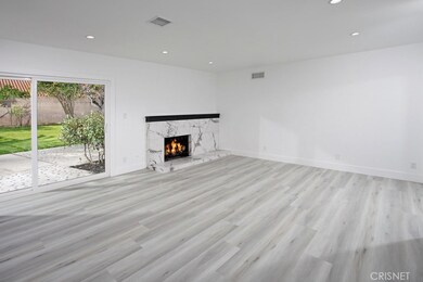 Living Room - New marble surround fireplace New sliding glass doors, New light switches and outlets, New base moldings and New wood - grained luxury vinyl tile flooring,