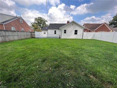 View of the back yard with vinyl and wood fence