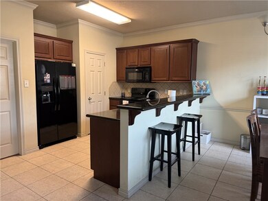 Kitchen with black appliances, dark countertops, a