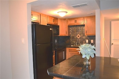 Wood cabinets, granite tile counter tops, black ap