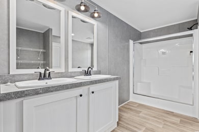 Full bath featuring double vanity, a shower, and wood finished floors