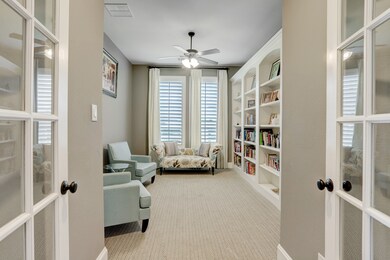Library features shuttered windows, custom shelving, and french doors. Could be used as an at home study or workout room!