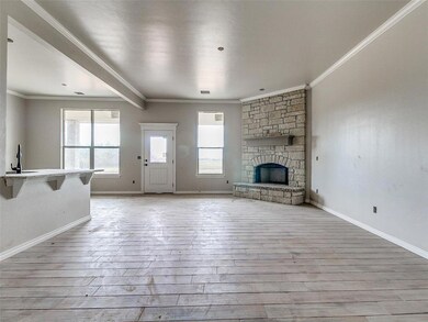 Unfurnished living room with crown molding, a ston