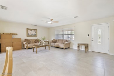 Living area featuring a ceiling fan, light tile pa