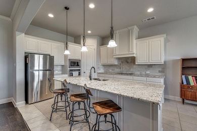Kitchen featuring visible vents, white cabinets, a