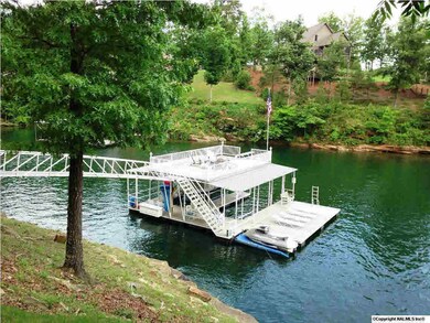 View of the double deck boat house with swim dock, double slips for boats, hydro hoist and jet ski lift.