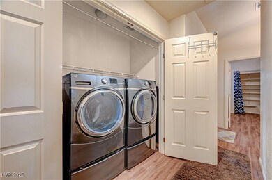 Clothes washing area with light wood-type flooring