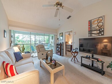 Living room with vaulted ceiling, light carpet, an