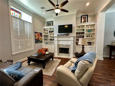 Den with Plantation shutters, fireplace, and built