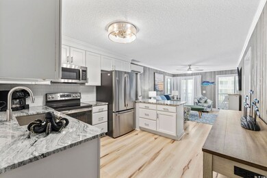 Kitchen with white cabinets, ceiling fan with nota