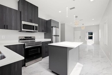 Kitchen featuring stainless steel appliances, light marble finish flooring, modern cabinets, light countertops, and recessed lighting
