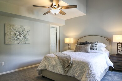 Primary bedroom features high ceiling and fan.