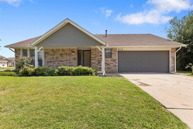 Ranch-style home with a garage, concrete driveway, a front yard, and brick siding