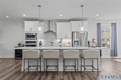 Kitchen featuring tasteful backsplash, white cabinets, dark wood finished floors, and recessed lighting