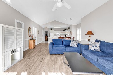 Living area with vaulted ceiling, a ceiling fan, light wood-type flooring, baseboards, and visible vents