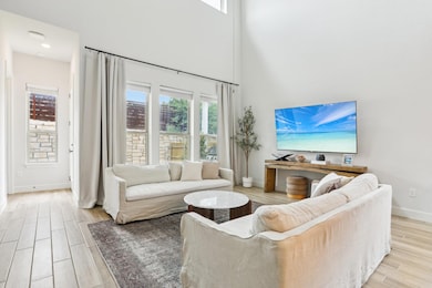 Living area featuring a high ceiling, baseboards,