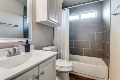 Full bathroom featuring toilet, oversized vanity, shower / bath combination with curtain, and hardwood / wood-style floors