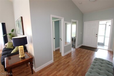 Foyer with light wood finished floors, high vaulte
