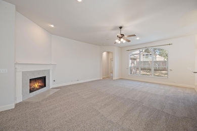 Unfurnished living room with light carpet, a fire