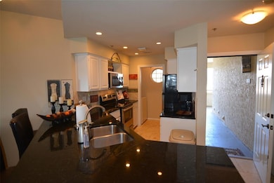 Kitchen featuring white cabinetry, stainless steel appliances, light tile patterned floors, recessed lighting, and backsplash