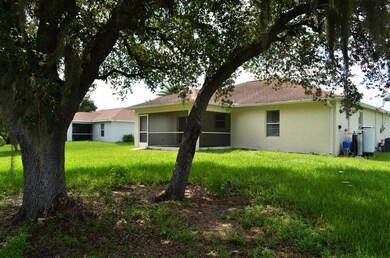 Rear view of property with stucco siding and a yard