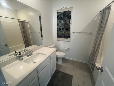 Bathroom with toilet, vanity, and a shower with sh
