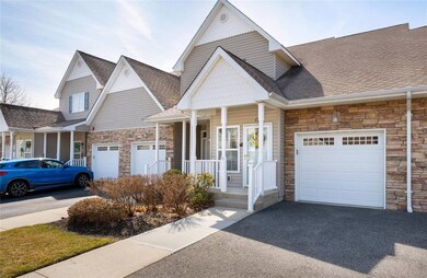 View of front facade with stone siding, driveway, 