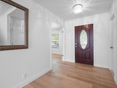 Foyer with wood finished floors and baseboards