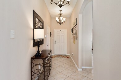Welcoming Front Entry with two Chandeliers. Kitchen and breakfast area to the right.