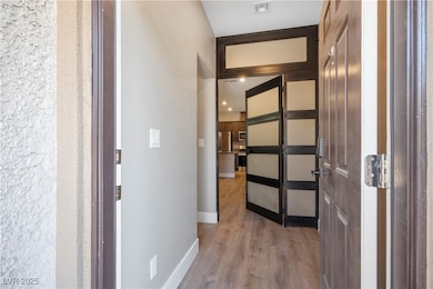 Hallway featuring light wood finished floors and baseboards
