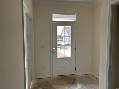 Entryway with baseboards, crown molding, and unfinished concrete floors