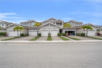 Townhome / multi-family property featuring stucco siding, driveway, and stone siding