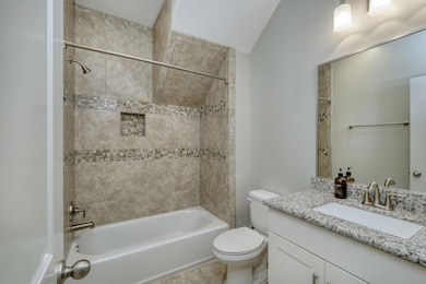 Bathroom with toilet, tile patterned flooring, ba