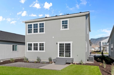 Back of property with stucco siding and a yard