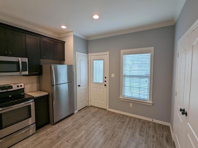 Kitchen with stainless steel appliances, ornamental molding, light wood-type flooring, tasteful backsplash, and recessed lighting