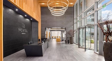 Welcome area with a high ceiling, floor to ceiling windows, and a chandelier