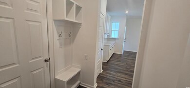 Mudroom with dark wood finished floors, baseboards, and recessed lighting